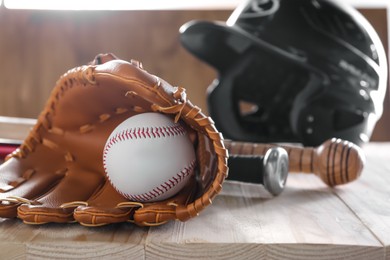 Baseball glove and ball on wooden table. Space for text