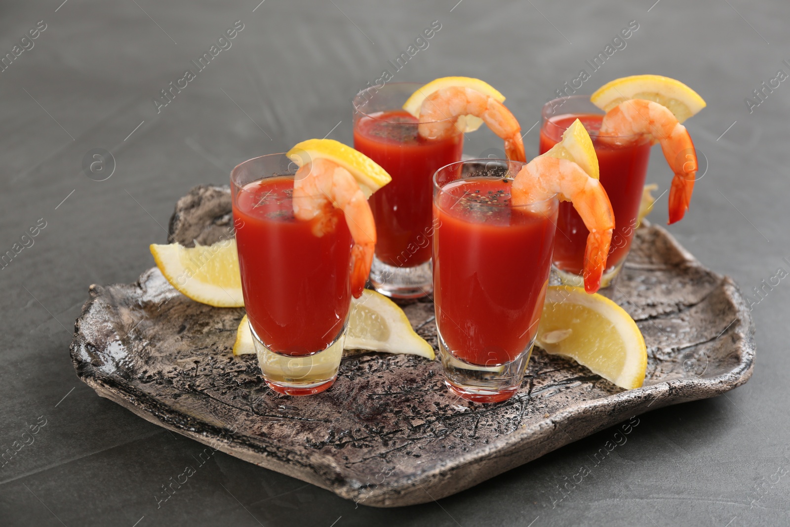 Photo of Delicious shrimp cocktail with tomato sauce on grey table