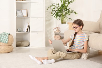 Photo of Girl with laptop sitting on floor at home