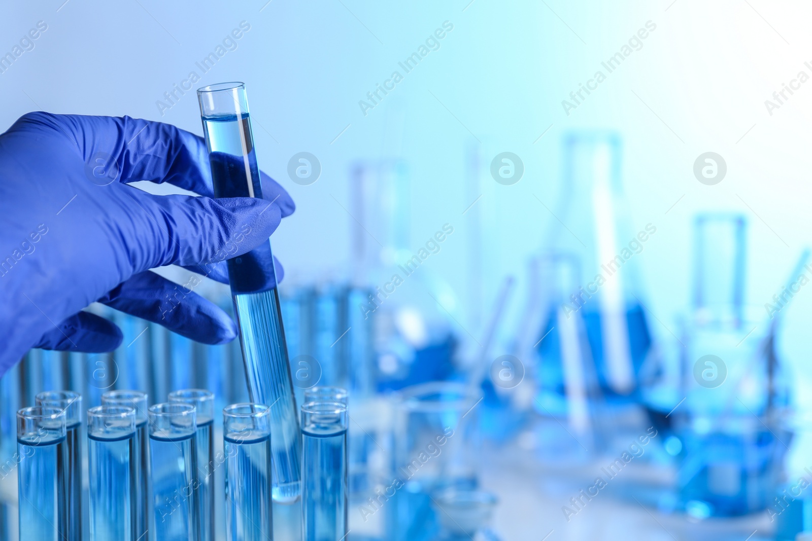 Photo of Doctor holding test tube with sample for analysis in laboratory, closeup