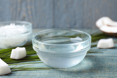 Photo of Coconut oil on light blue wooden table