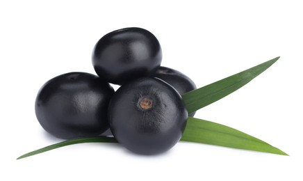 Photo of Pile of fresh ripe acai berries and green leaves on white background