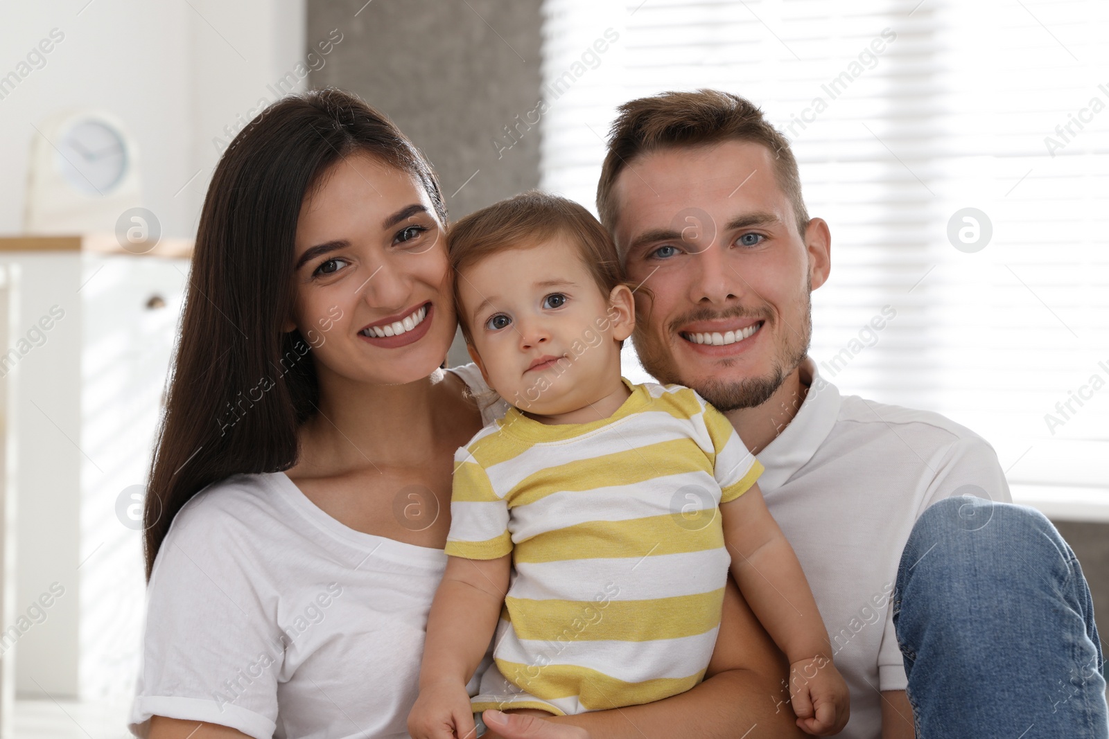 Photo of Happy family with adorable little baby at home