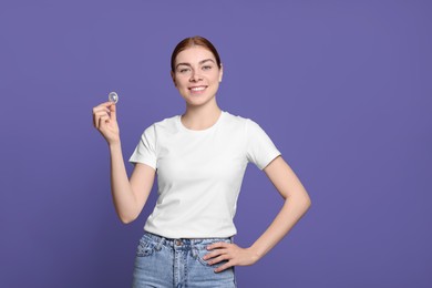 Photo of Woman holding condom on purple background. Safe sex