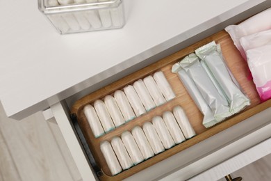 Storage of different feminine products in white drawer indoors, top view
