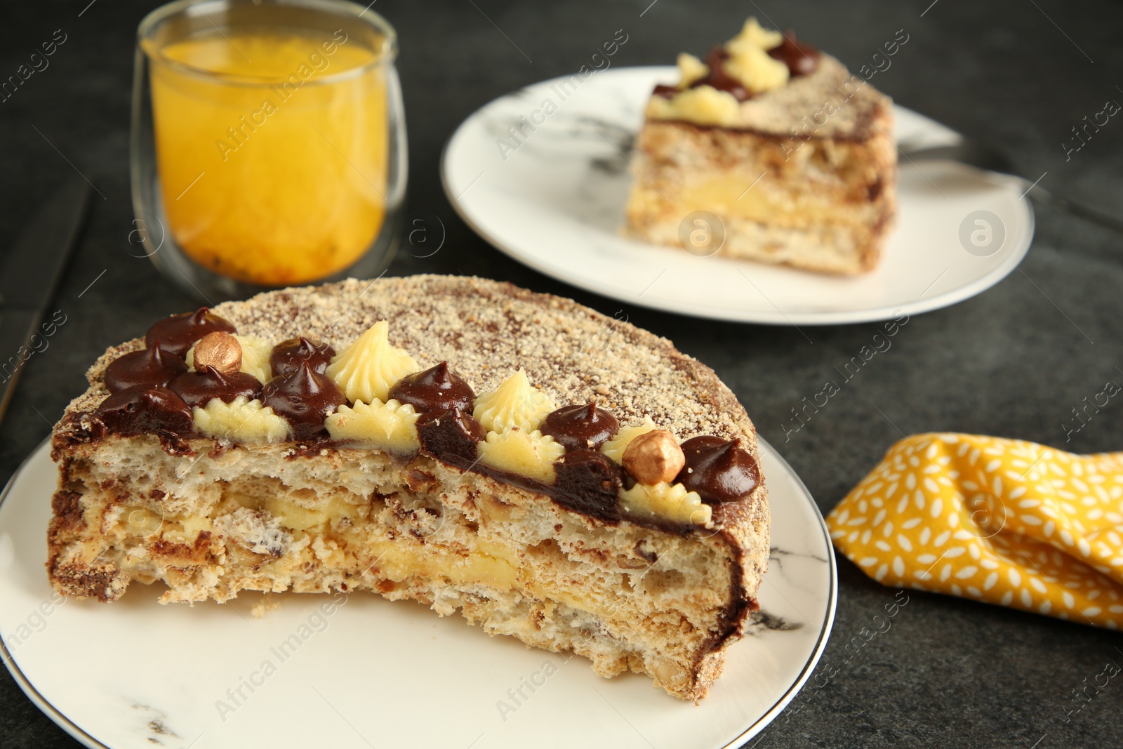 Photo of Delicious Kyiv Cake served with drink on black table, closeup