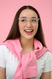 Photo of Happy woman wearing glasses on pink background