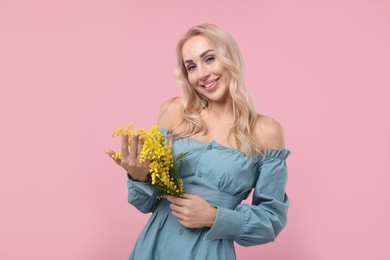 Photo of Happy young woman with beautiful bouquet on dusty pink background