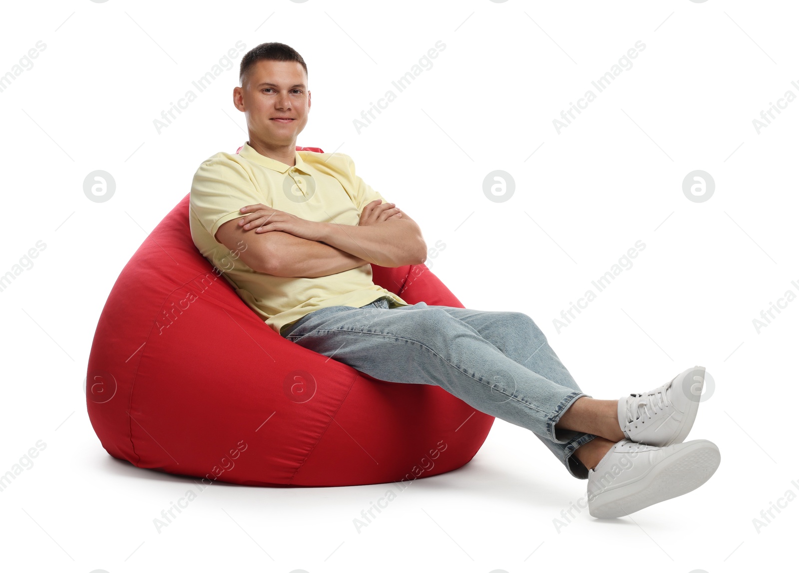 Photo of Handsome man sitting on red bean bag chair against white background