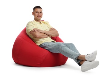 Photo of Handsome man sitting on red bean bag chair against white background