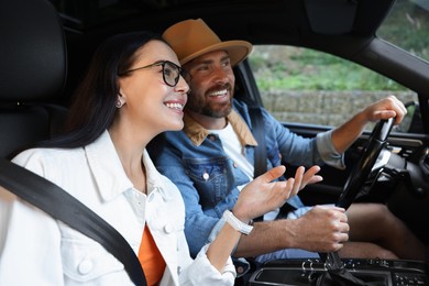 Photo of Happy couple enjoying trip together by car