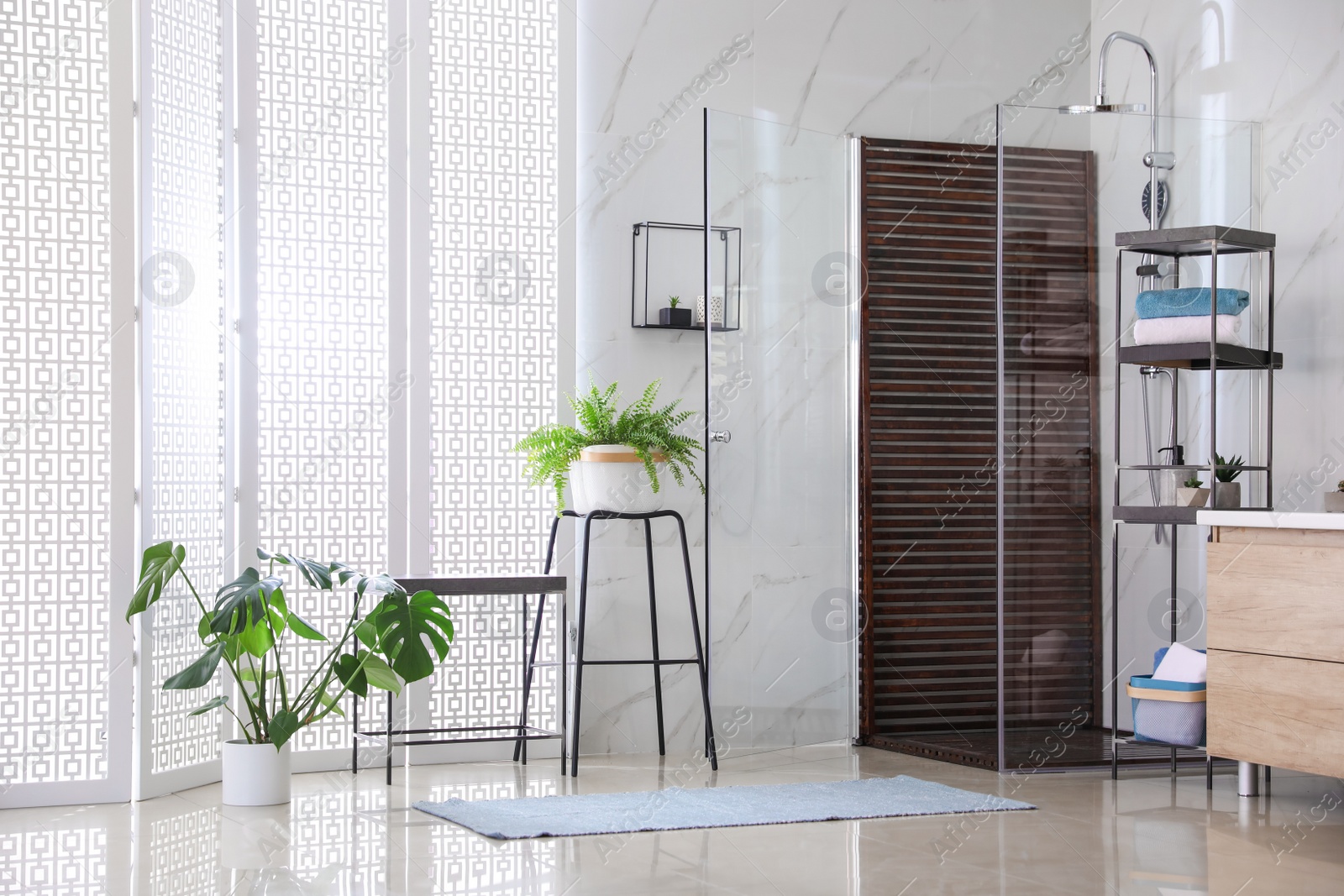 Photo of Bathroom interior with shower stall and houseplants. Idea for design