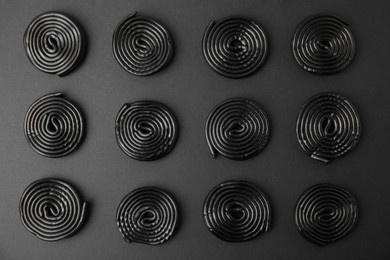 Photo of Tasty liquorice candies on black background, flat lay