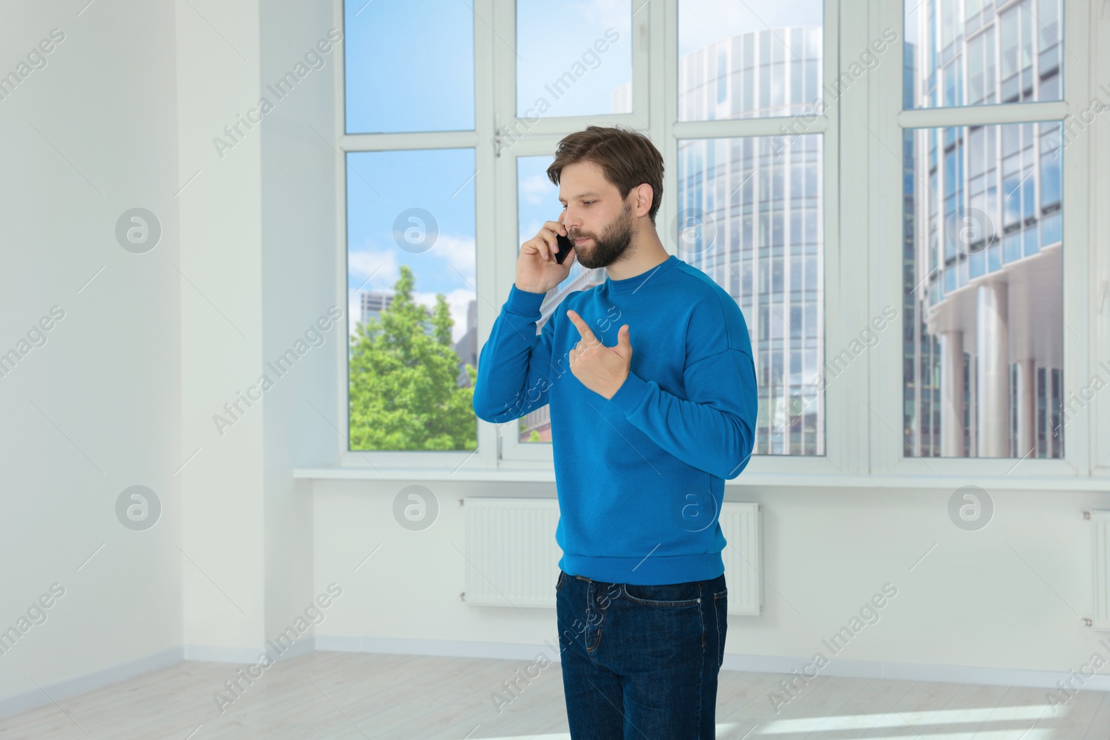 Photo of Man in casual clothes talking on phone indoors, space for text