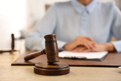 Photo of Notary with clipboard writing notes at workplace in office, focus on mallet