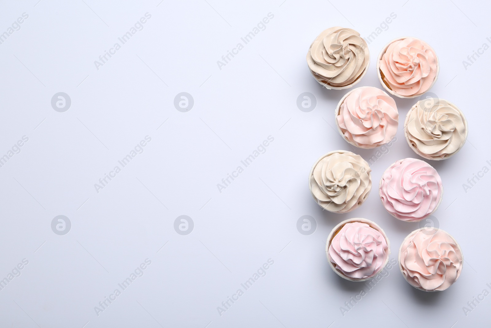 Photo of Many tasty cupcakes on white background, flat lay. Space for text