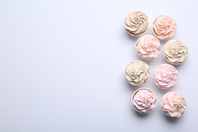 Many tasty cupcakes on white background, flat lay. Space for text