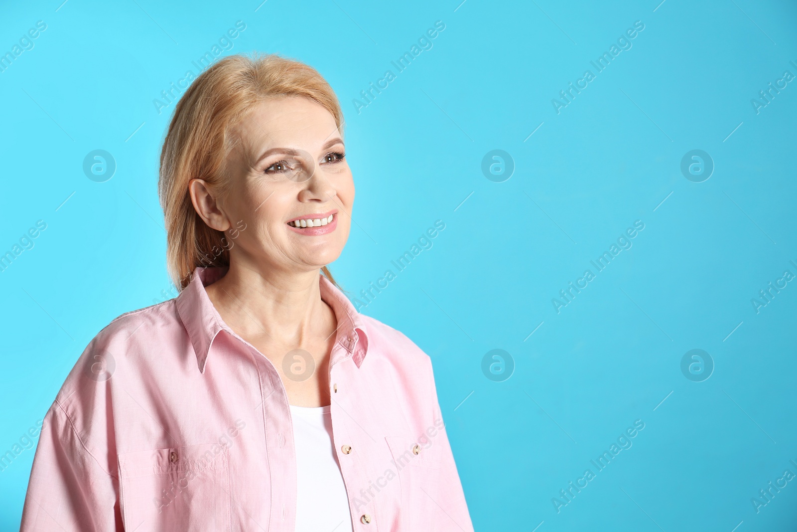 Photo of Portrait of mature woman with beautiful face on blue background. Space for text