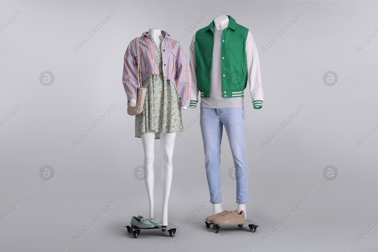 Photo of Male and female mannequins dressed in stylish outfits on grey background