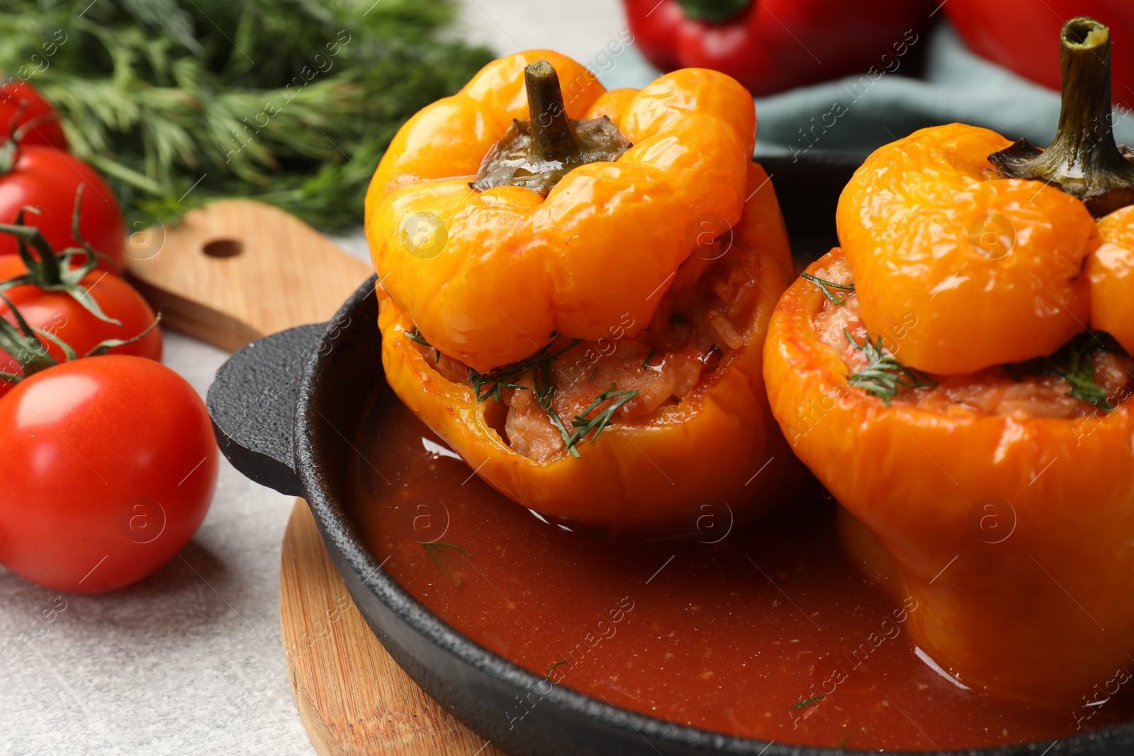 Photo of Tasty stuffed peppers on light grey table, closeup