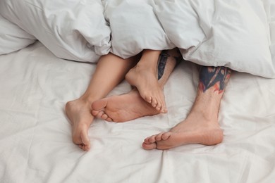Passionate couple having sex on bed, closeup of legs