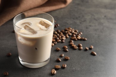 Coffee cream liqueur in glass and beans on grey table