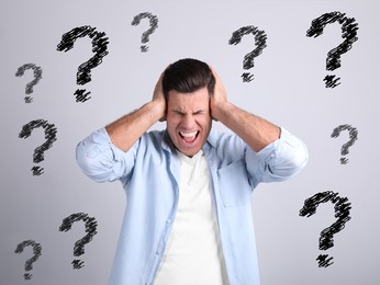Image of Amnesia. Stressed man and question marks on light background