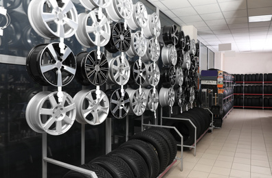 Car tires and alloy wheels on rack in auto store