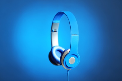 Photo of Stylish headphones with pads on color background