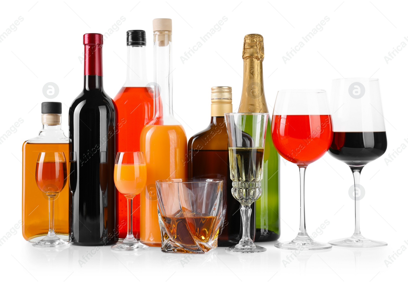 Photo of Bottles and glasses with different alcoholic drinks isolated on white