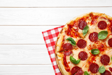 Photo of Hot delicious pepperoni pizza on white wooden table, top view. Space for text