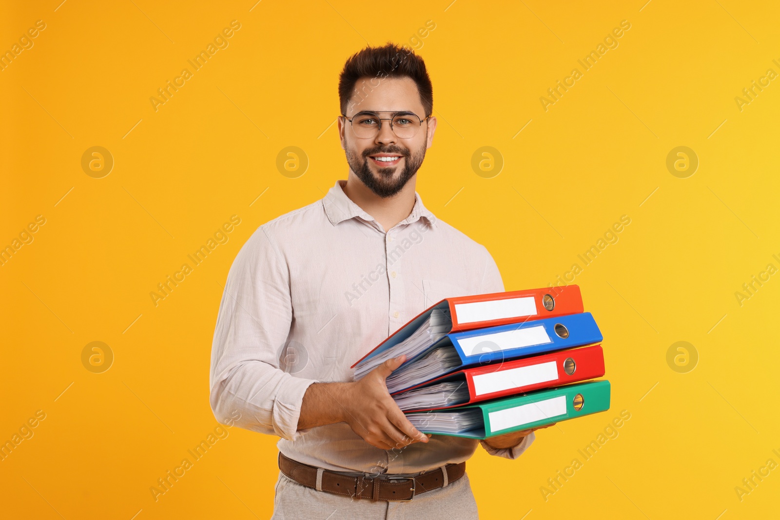 Photo of Happy man with folders on orange background