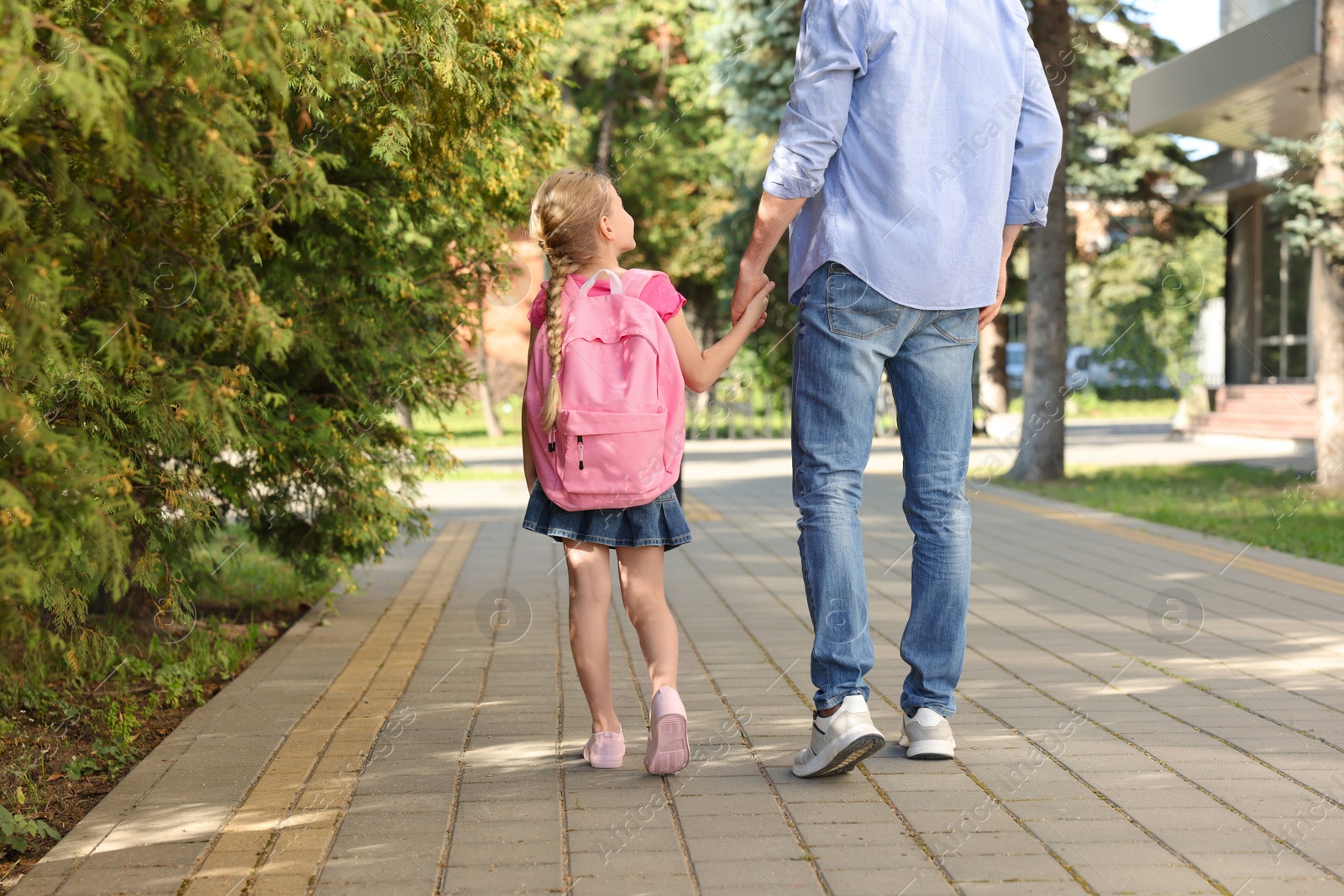 Photo of Little girl with her father on way to school