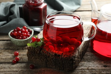 Photo of Delicious cranberry tea and berries on wooden table