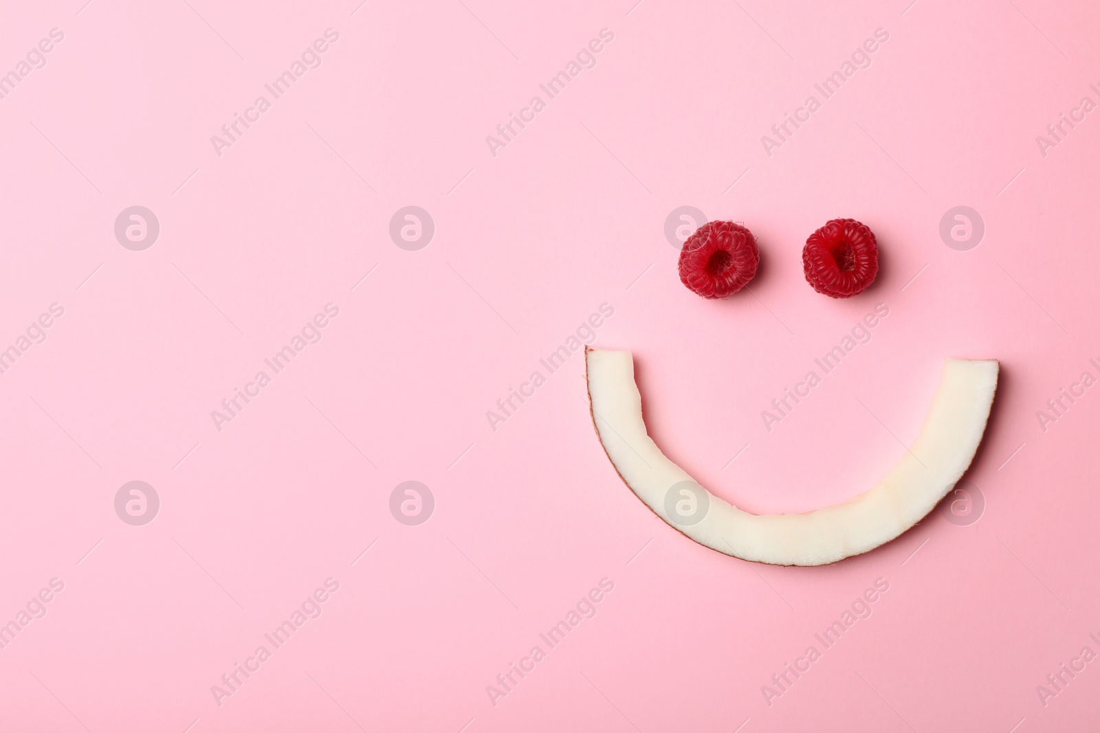 Photo of Funny flat lay composition with coconut and raspberry on color background. Space for text