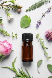 Photo of Bottle of essential oil, different herbs and flowers on white background, flat lay