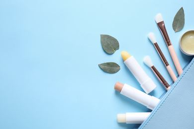 Photo of Flat lay composition with hygienic lipsticks on light blue background, space for text