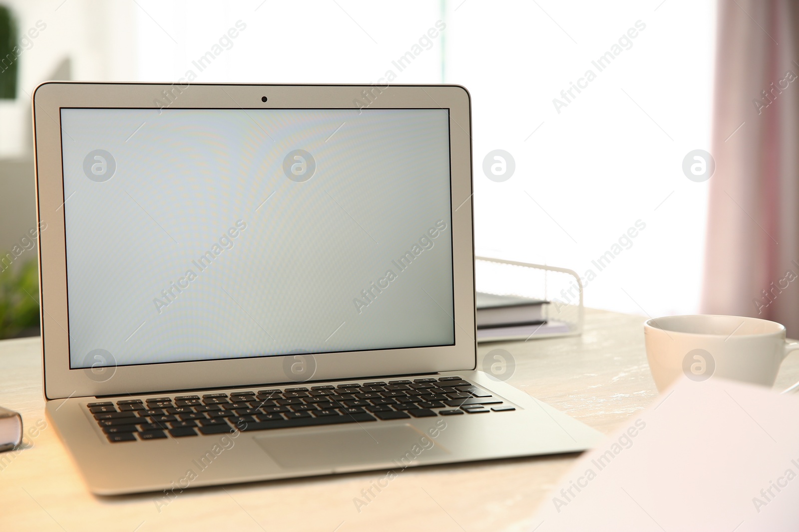 Photo of Modern laptop and cup of coffee on white table indoors. Space for design