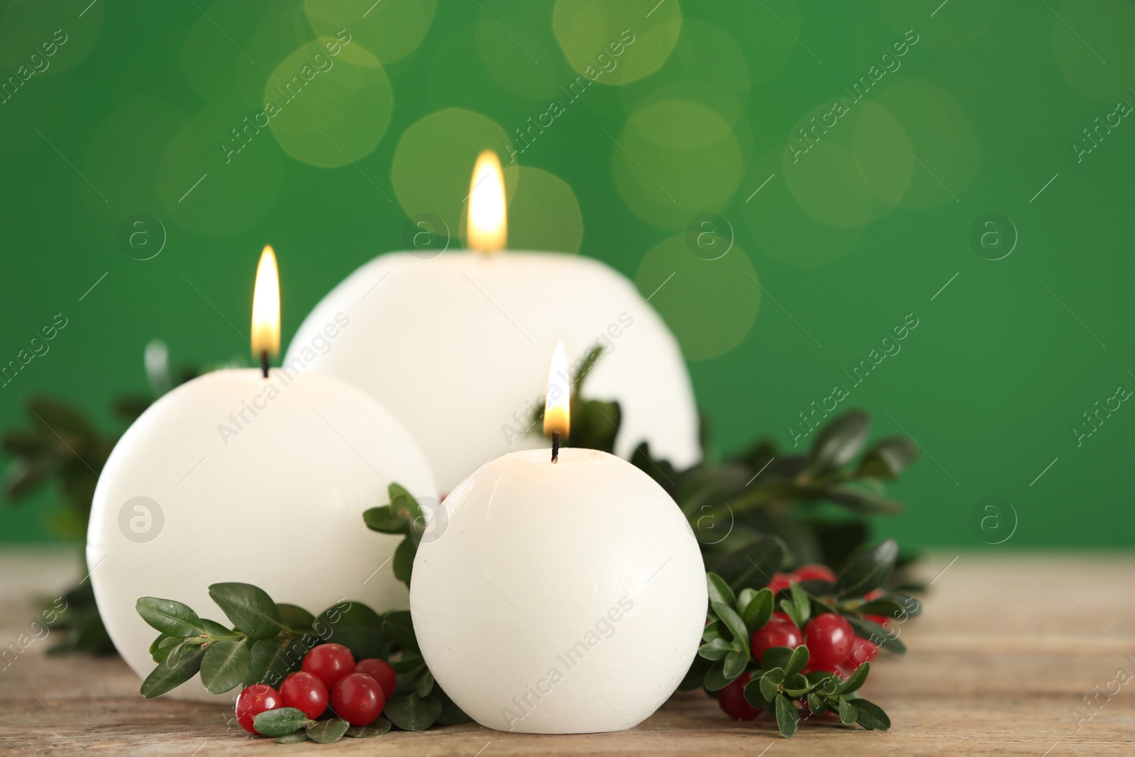 Photo of Beautiful Christmas composition with burning candles on table against green background