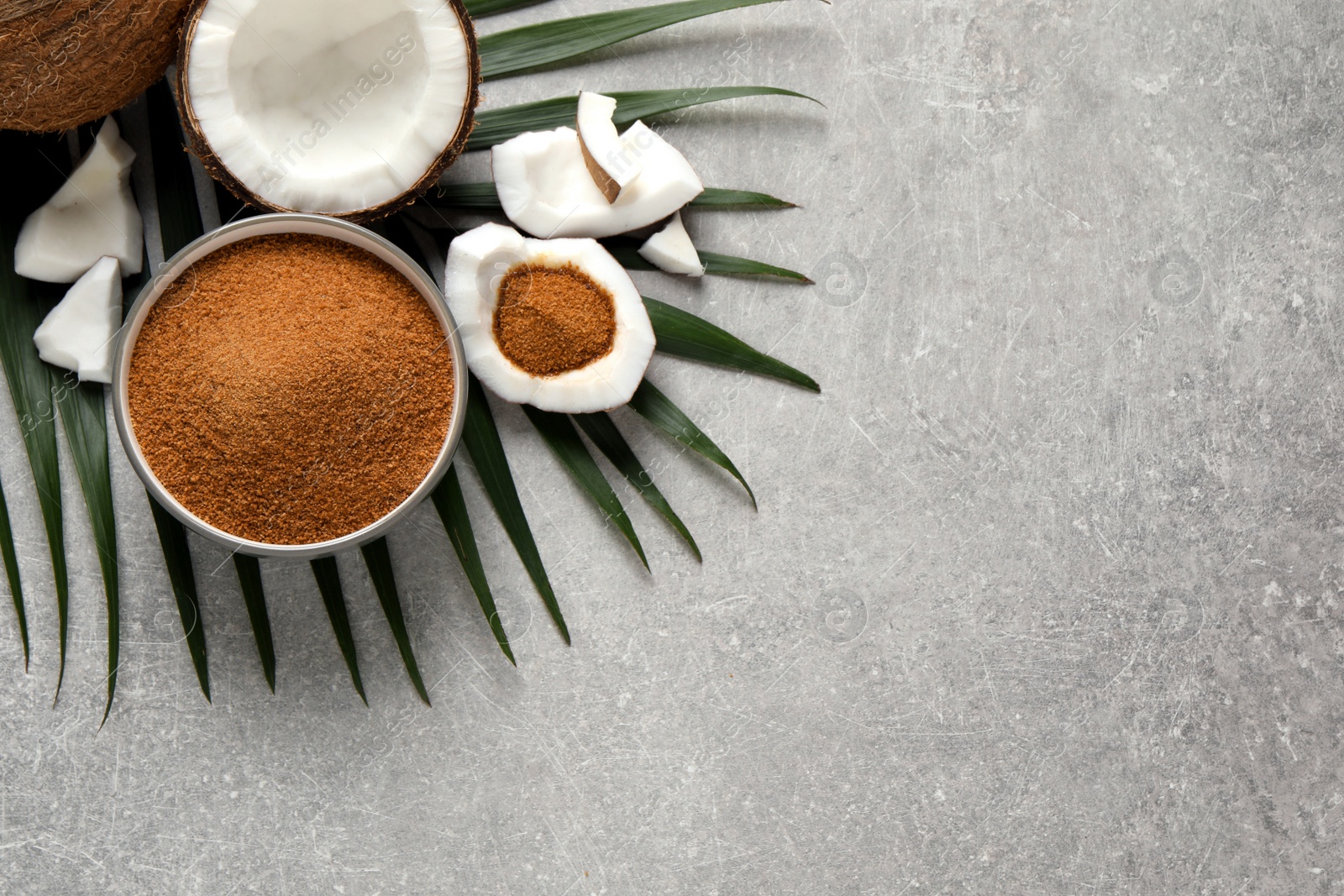 Photo of Flat lay composition with natural coconut sugar on grey table, space for text