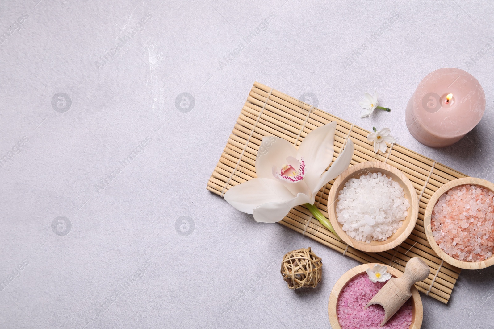 Photo of Flat lay composition with different spa products and orchid on light grey table. Space for text