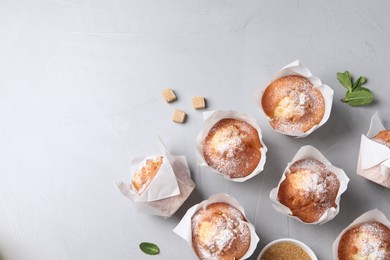 Photo of Delicious muffins on grey table, flat lay. Space for text