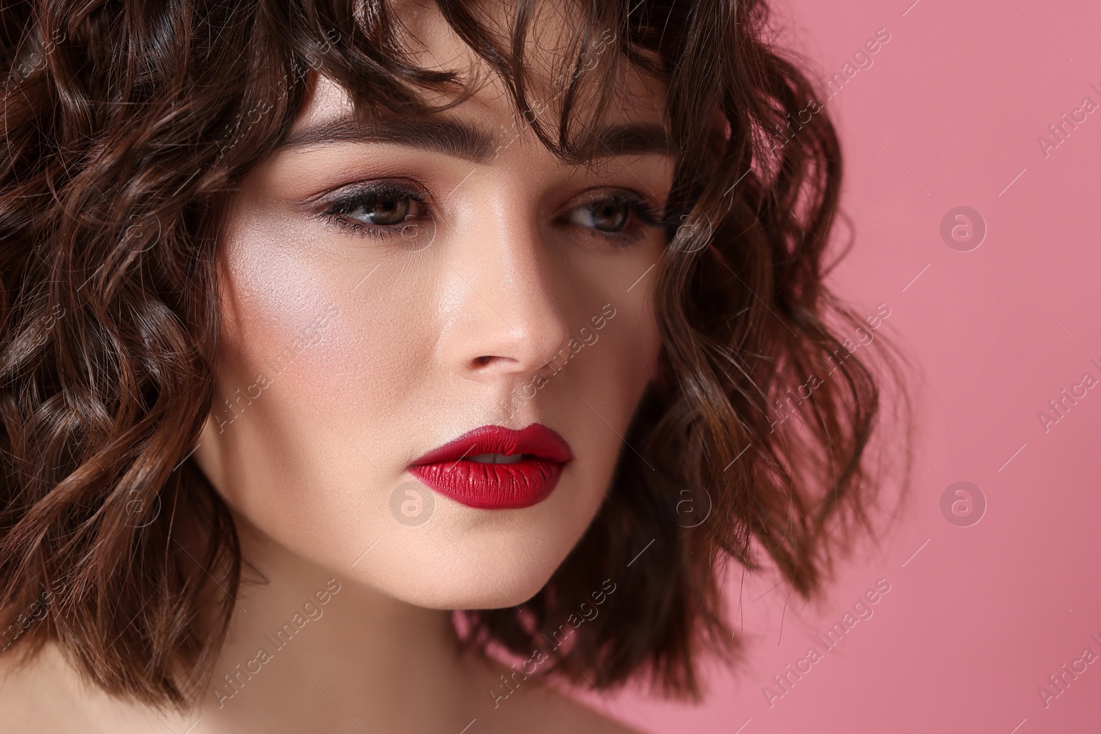 Photo of Beautiful young woman with wavy hairstyle on pink background