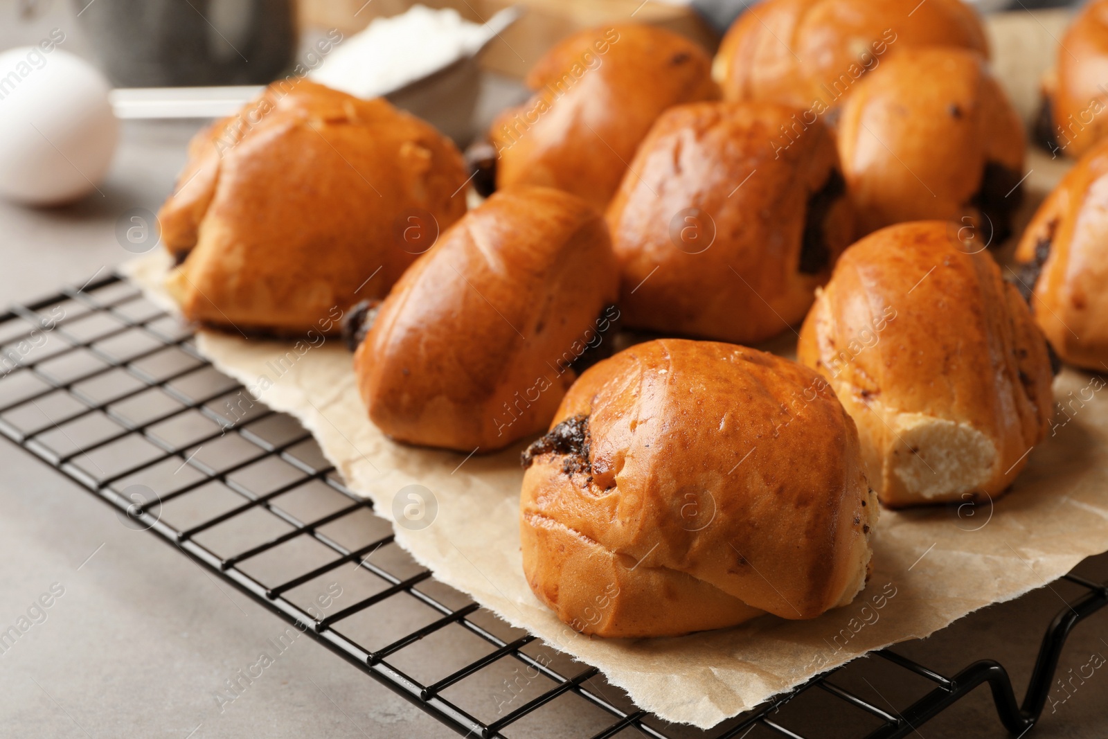 Photo of Cooling rack with freshly baked poppy seed buns on table