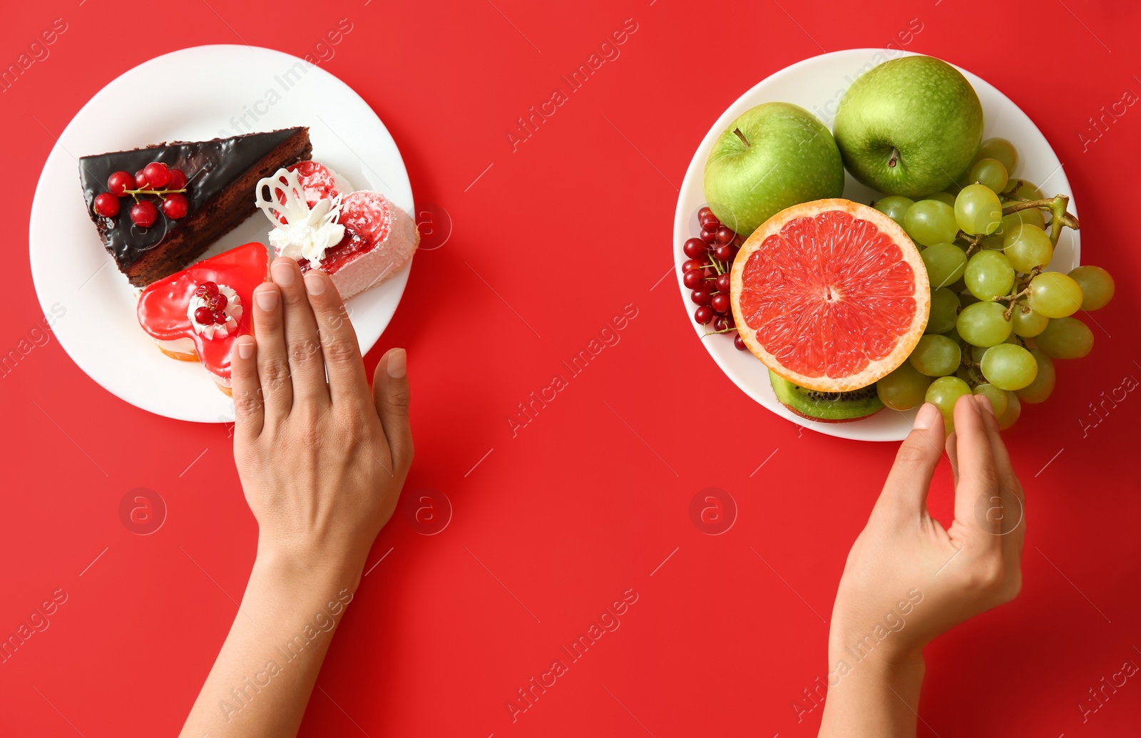 Photo of Top view of woman choosing between sweets and healthy fruits on red background, closeup