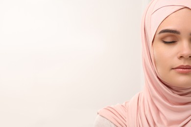 Photo of Muslim woman wearing hijab indoors, space for text