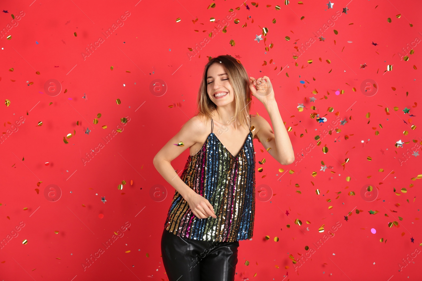 Photo of Happy woman and falling confetti on red background