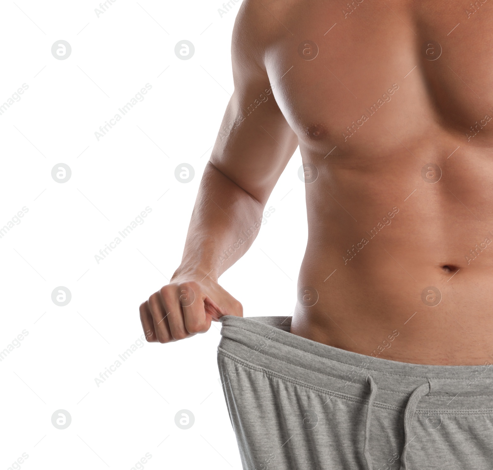 Photo of Young man with slim body in old big size pants on white background, closeup view