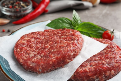 Photo of Raw meat cutlets for burger on table, closeup