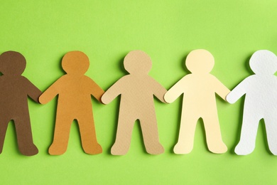 Photo of Paper people holding hands on color background, top view. Unity concept